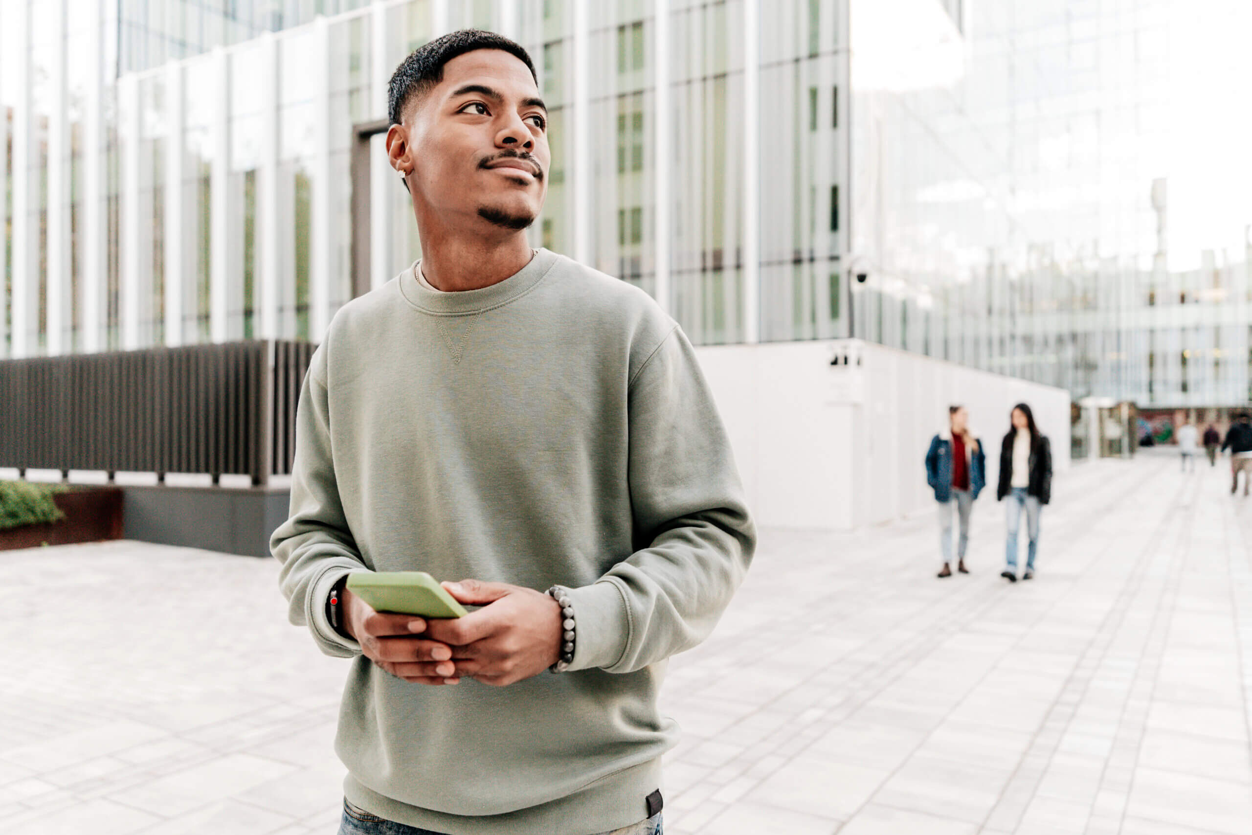 Photo with copy space of a student using phone distracted looking up in the campus